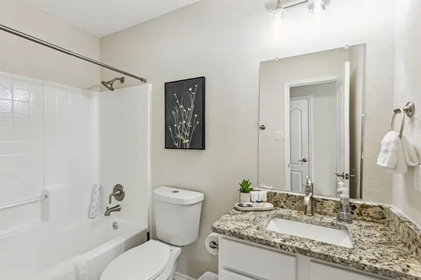 a bathroom with a granite countertop sink toilet and shower