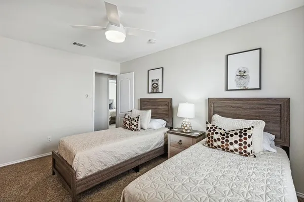 a bedroom with two beds and painting on the wall