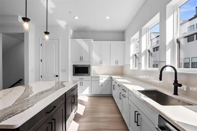 a large kitchen with kitchen island a sink appliances and cabinets
