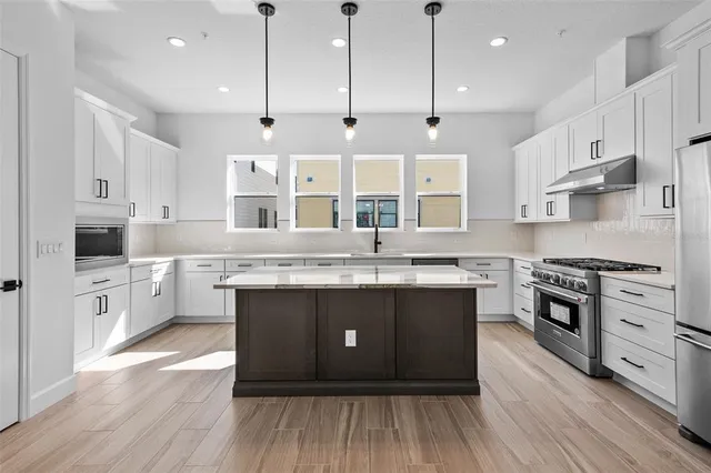 a kitchen with stainless steel appliances granite countertop a stove and a sink