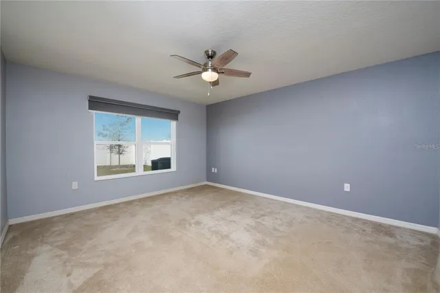 a view of an empty room with a ceiling fan