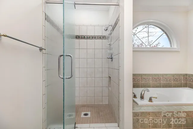 a bathroom with a bathtub a window and a shower