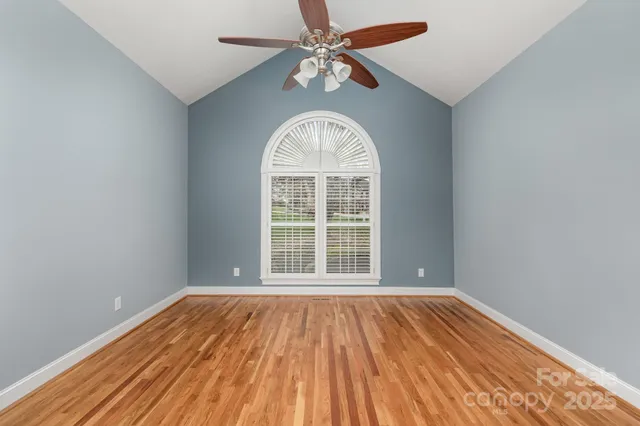 an empty room with a window and wooden floor