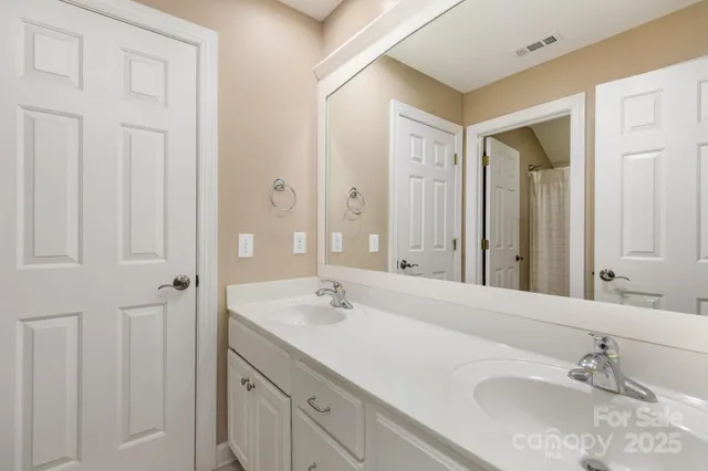a bathroom with double vanity sink and a mirror