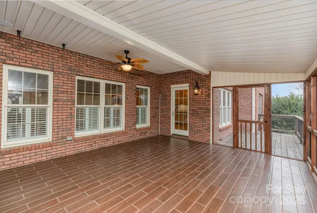 a view of empty room with wooden floor and floor to ceiling window