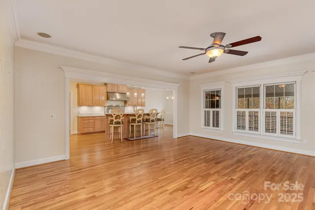 a view of a livingroom with furniture wooden floor and a ceiling fan