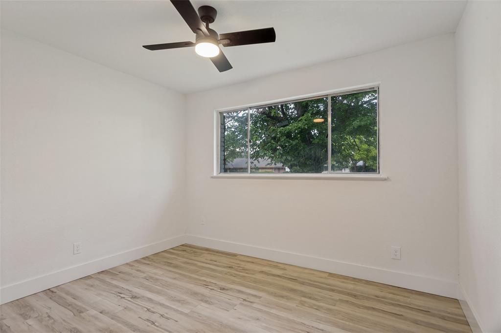 3816 Springbranch Drive Benbrook, TX 76116 - Photo 22 of 25 an empty room with wooden floor and windows