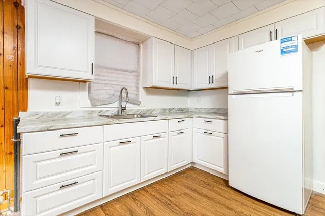 a kitchen with granite countertop cabinets appliances a sink and a window