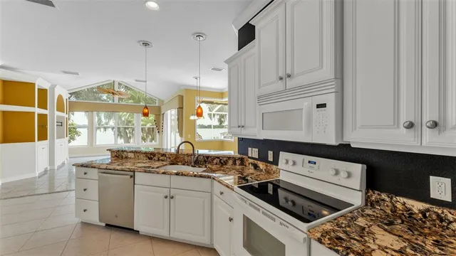 a bathroom with a granite countertop tub a window and a sink