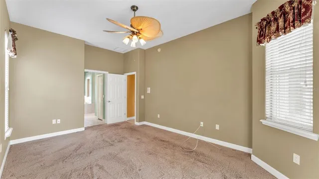 an empty room with a window and a fan