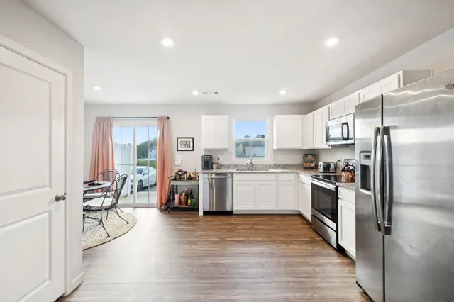 a kitchen with a refrigerator cabinets and wooden floor