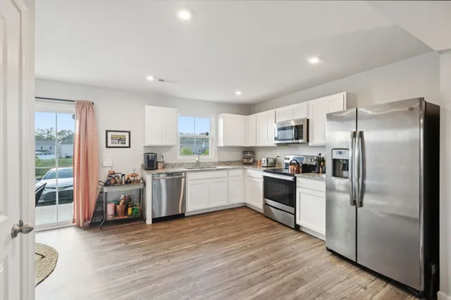 a kitchen with stainless steel appliances granite countertop a refrigerator sink and microwave