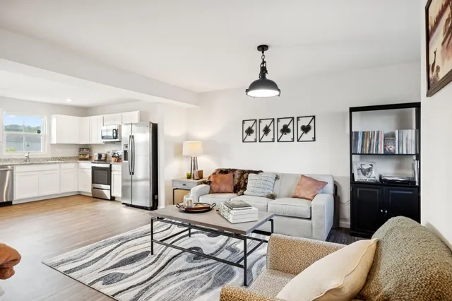 a living room with furniture and kitchen view