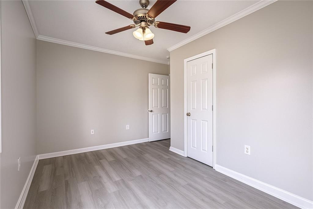 949 Washington Street Southwest, Unit 16 Atlanta, GA 30315 - Photo 4 of 14 an empty room with a ceiling fan and wooden floor