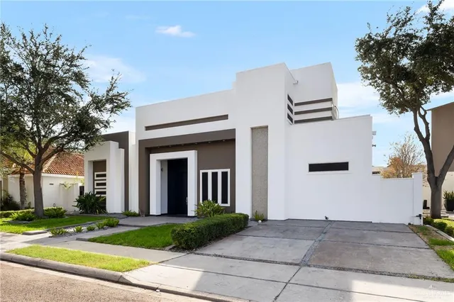 a view of a white house with a large tree