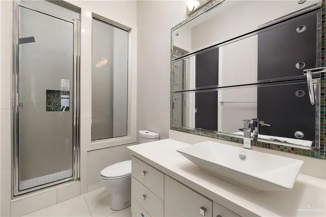 a bathroom with a sink and mirror with toilet