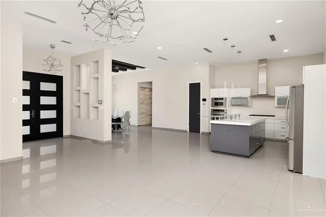 a kitchen with stainless steel appliances kitchen island granite countertop a refrigerator and a stove top oven