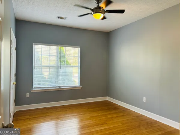 a view of an empty room with wooden floor