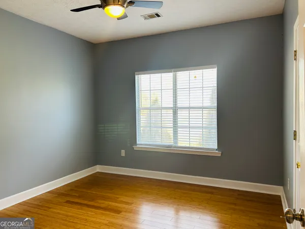 a view of an empty room with wooden floor