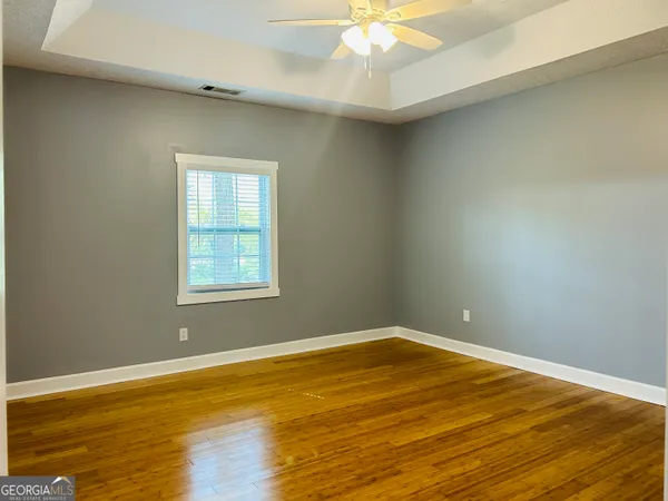 a view of an empty room with wooden floor