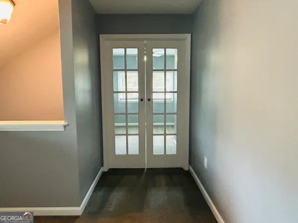 an empty room with windows and fan