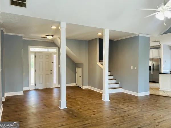 a view of a hallway with wooden floor and staircase