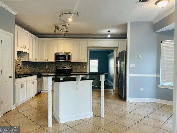 a kitchen with granite countertop a sink cabinets and stainless steel appliances