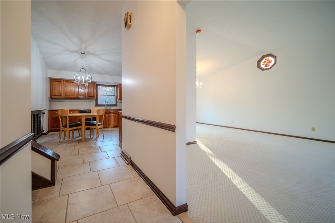 698 Albert Horning Road Atwater, OH 44201 - Photo 17 of 40 Hall featuring vaulted ceiling, a chandelier, and light tile patterned flooring
