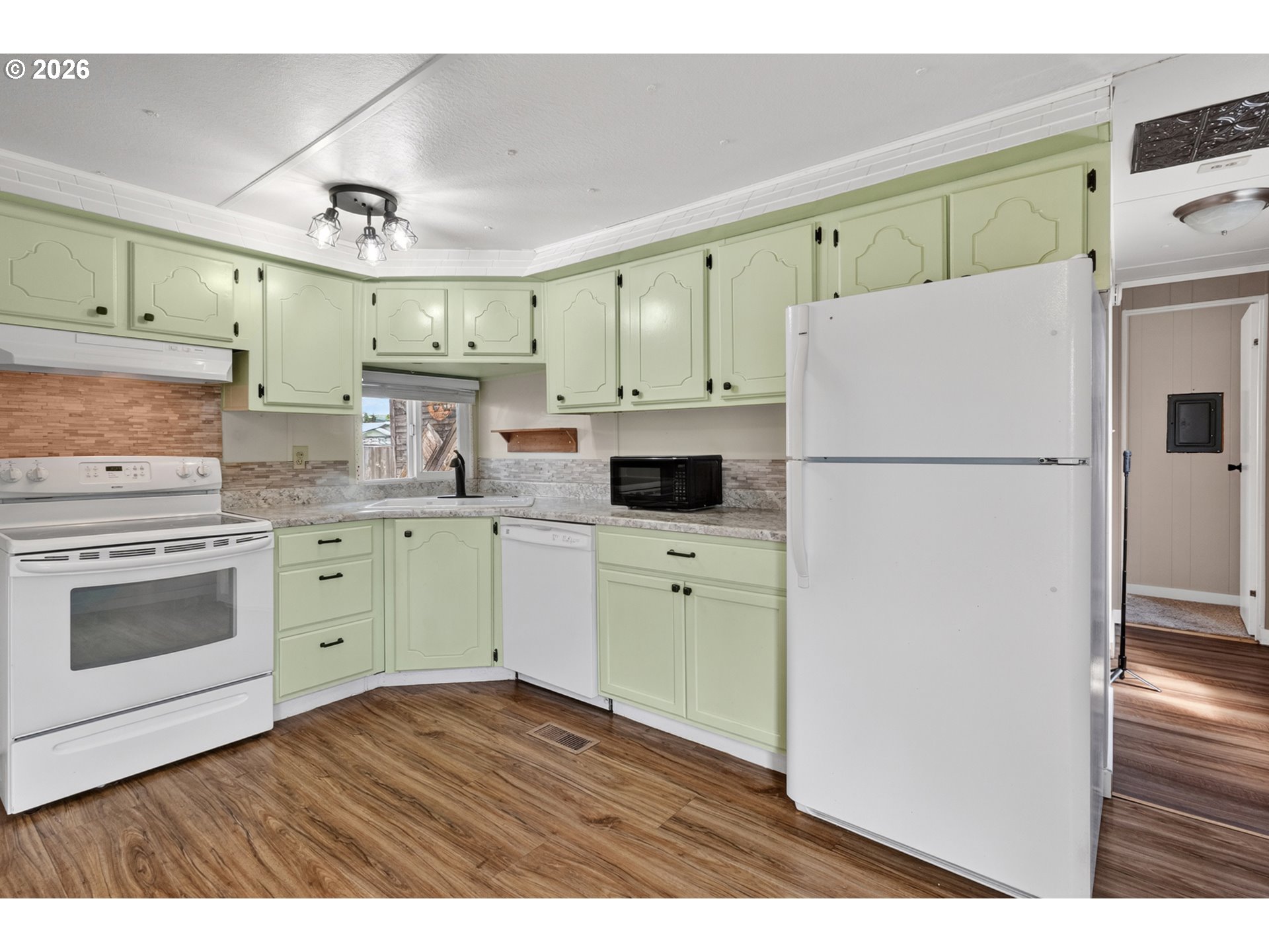 205 South 54th Street, Unit 80 Springfield, OR 97478 - Photo 9 of 37 a kitchen with a refrigerator a stove a sink cabinets and wooden floor