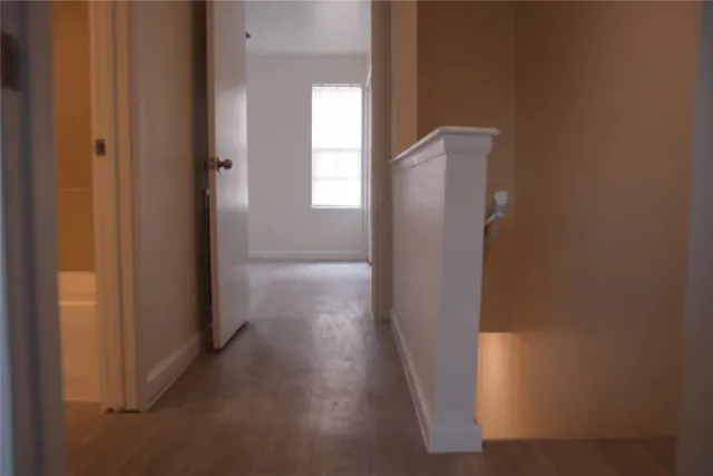 a view of a hallway with wooden floor
