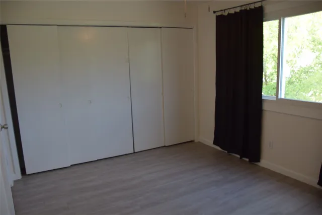 a view of a small space with wooden floor and a window