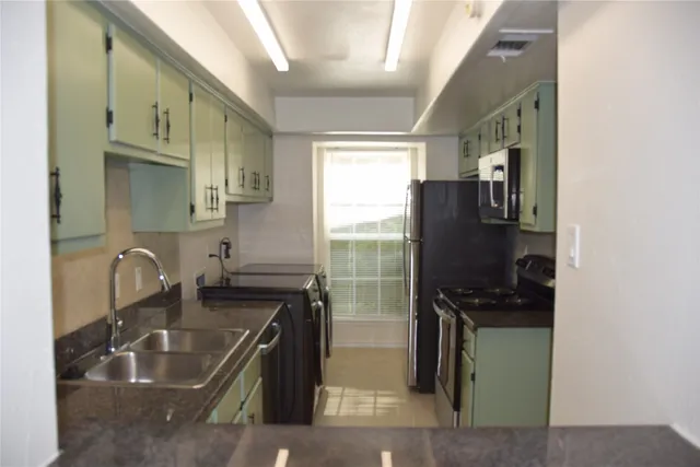 a kitchen with a sink appliances and cabinets