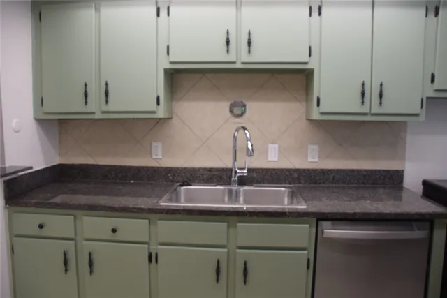 a kitchen with granite countertop white cabinets and a sink