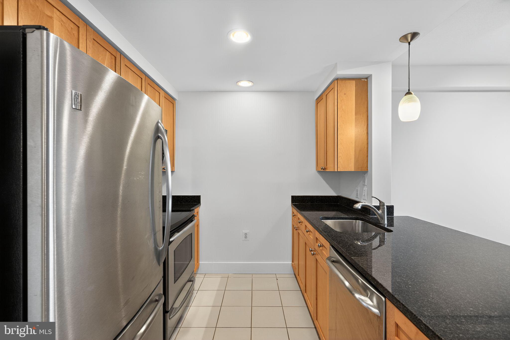 2001 15th Street North, Unit 420 Arlington, VA 22201 - Photo 12 of 27 a kitchen with stainless steel appliances granite countertop a refrigerator a stove and a sink