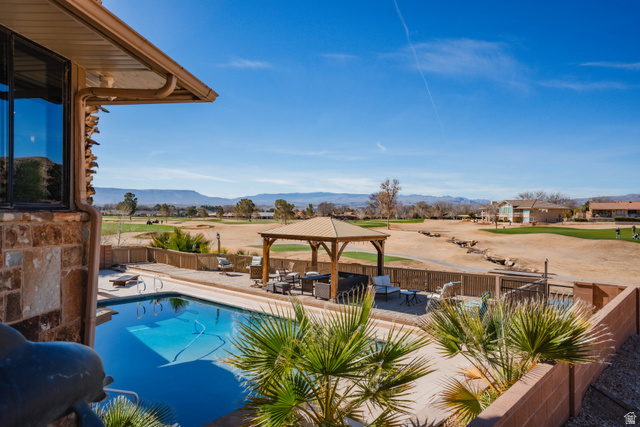 980 Cactus Circle St. George, UT 84790 - Photo 67 of 77 View of swimming pool with a gazebo, patio surround, a mountain view, a fenced backyard, and view of golf course