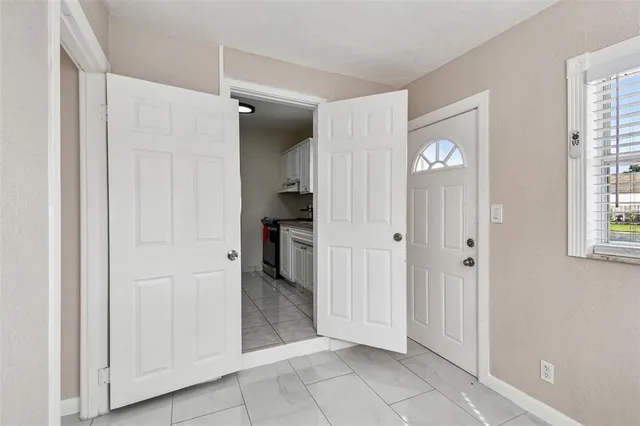 a view of a hallway with bathroom and a window