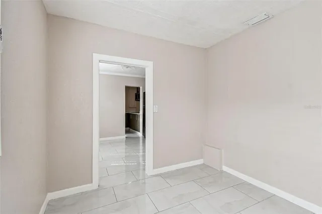 a view of an empty room with closet and a window