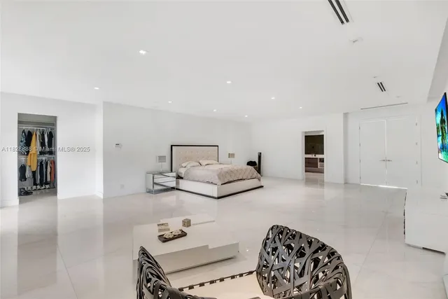 a bedroom with a large bed couch and a window