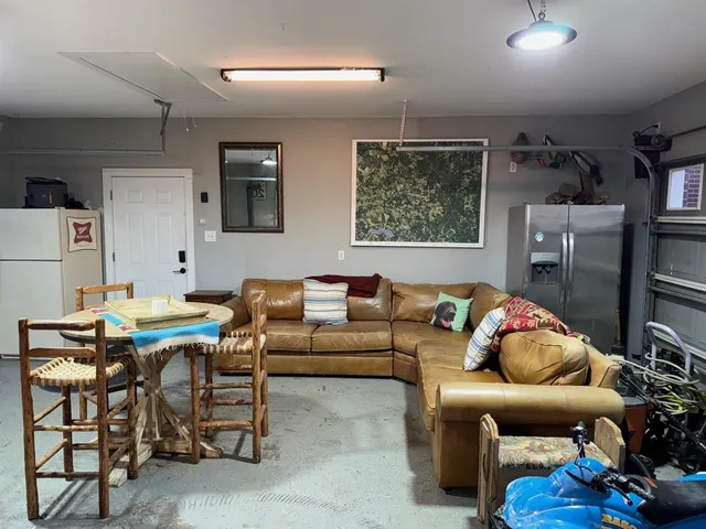 a living room with furniture a rug and white walls