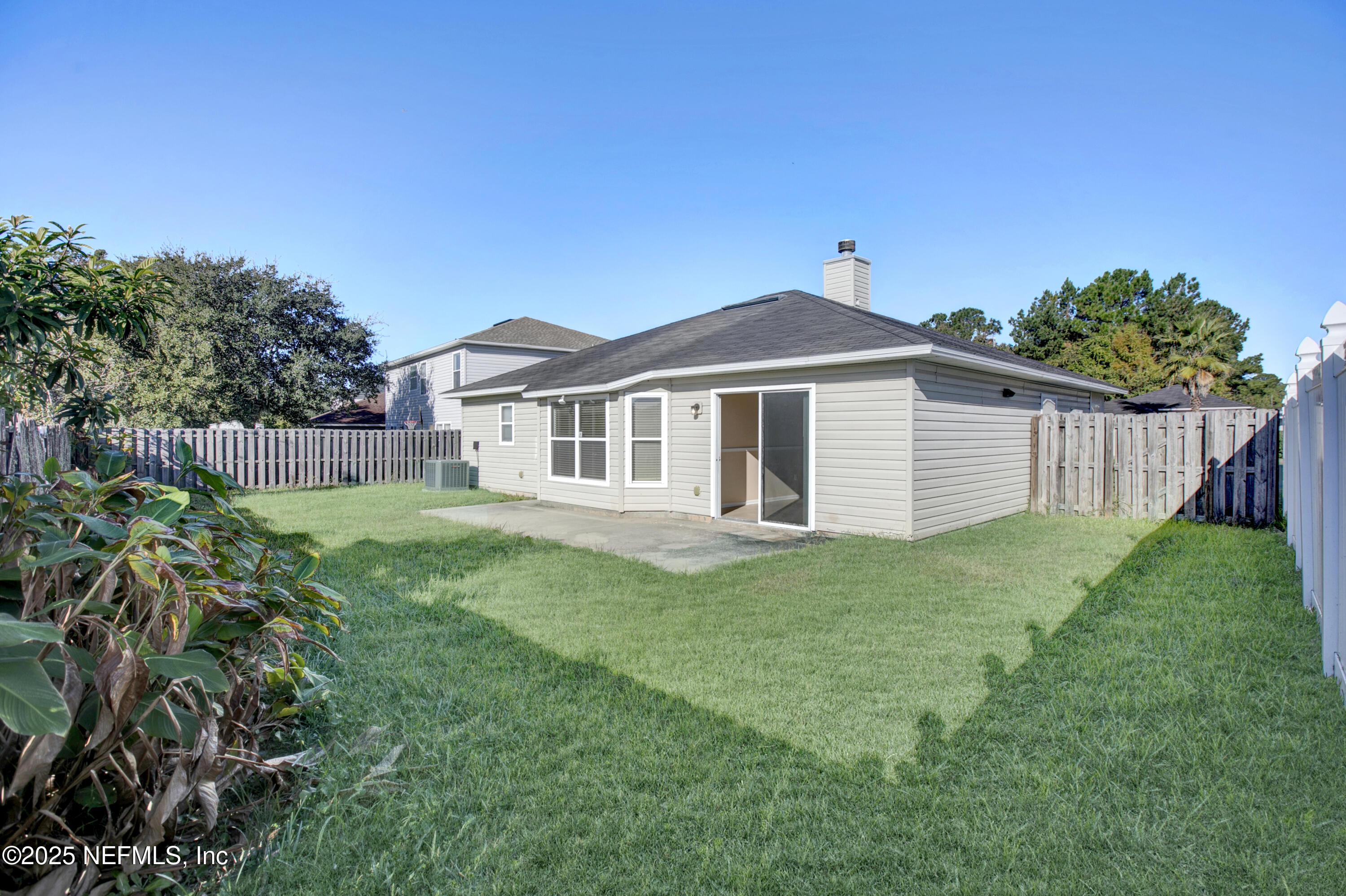 1164 Dawn Light Road Jacksonville, FL 32218 - Photo 18 of 19 a white house with a small yard and wooden fence