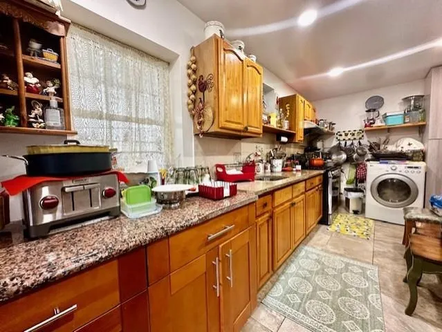 a kitchen with stainless steel appliances granite countertop a refrigerator a stove and a sink with wooden floor