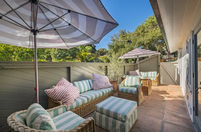 a view of patio with couches table and chairs under an umbrella