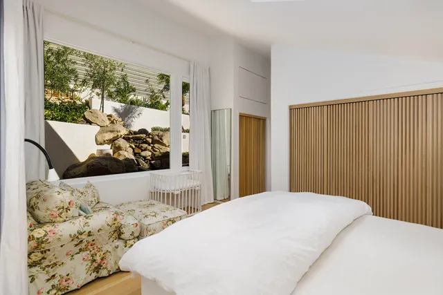 a bed sitting in a bedroom next to a window