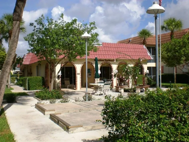 a view of a house with brick walls and a yard with plants
