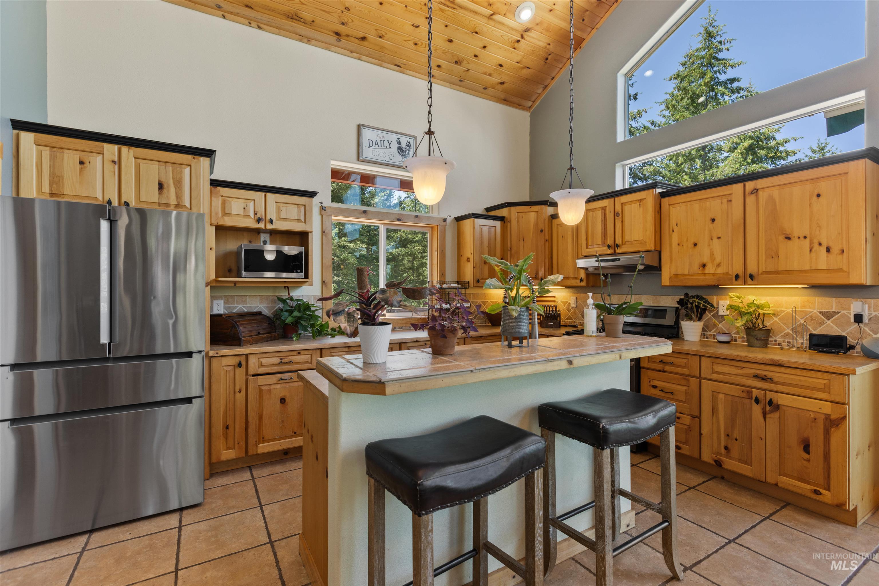 60 Highland Road Boise, ID 83716 - Photo 15 of 42 Kitchen featuring wood ceiling, appliances with stainless steel finishes, light tile patterned floors, tasteful backsplash, and high vaulted ceiling