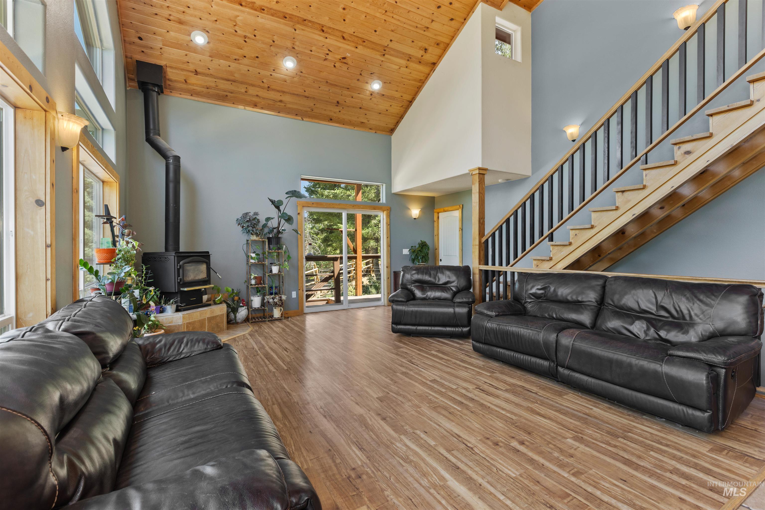 60 Highland Road Boise, ID 83716 - Photo 20 of 42 Living area with a wood stove, wood ceiling, high vaulted ceiling, wood finished floors, and stairway