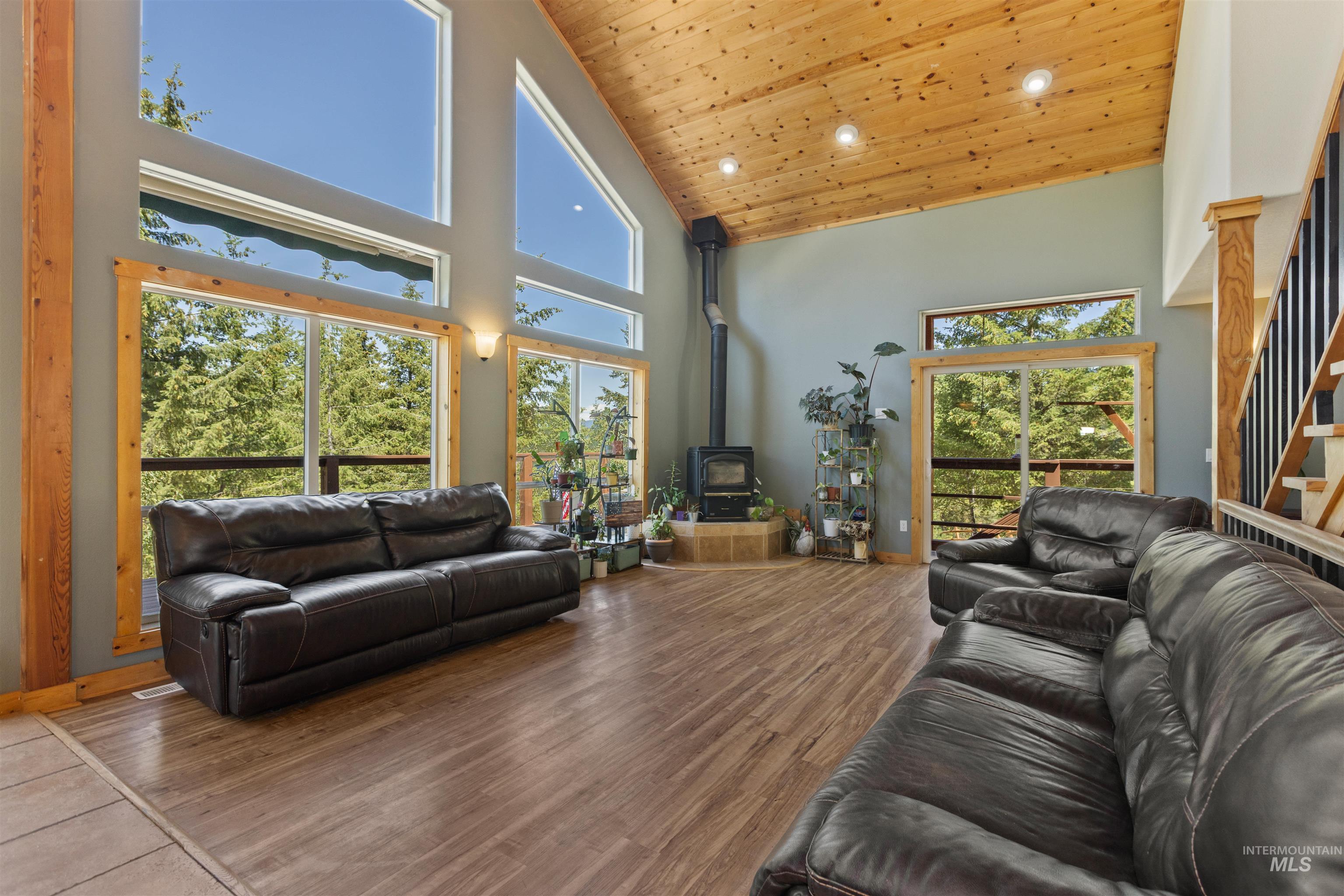 60 Highland Road Boise, ID 83716 - Photo 21 of 42 Living room with wood ceiling, a wood stove, stairs, wood finished floors, and high vaulted ceiling