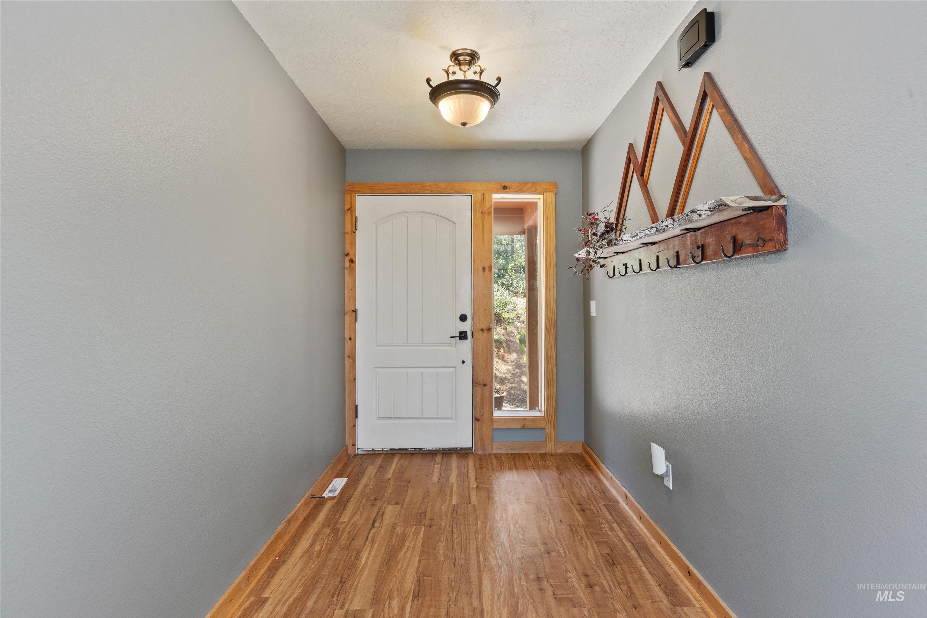 60 Highland Road Boise, ID 83716 - Photo 7 of 42 Doorway with light wood-style floors and baseboards