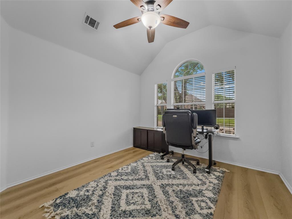 3008 Devlin Ridge Drive Plano, TX 75025 - Photo 13 of 24 Vaulted ceiling room featuring light-toned wood-finish flooring, a ceiling fan with light fixture, and three windows including an arched transom