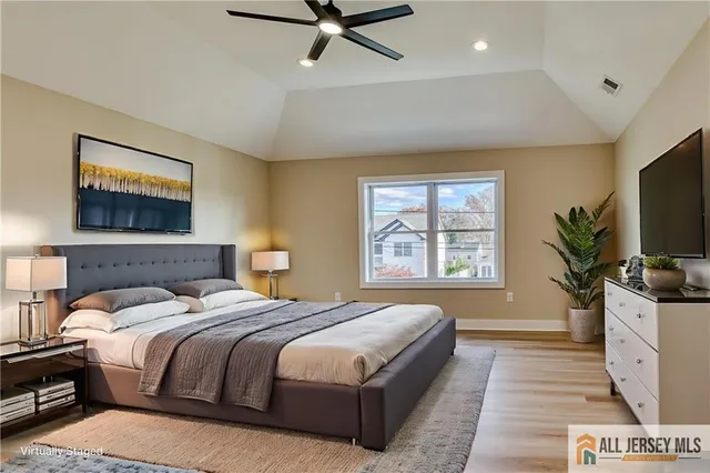 a bedroom with a large bed and a flat screen tv